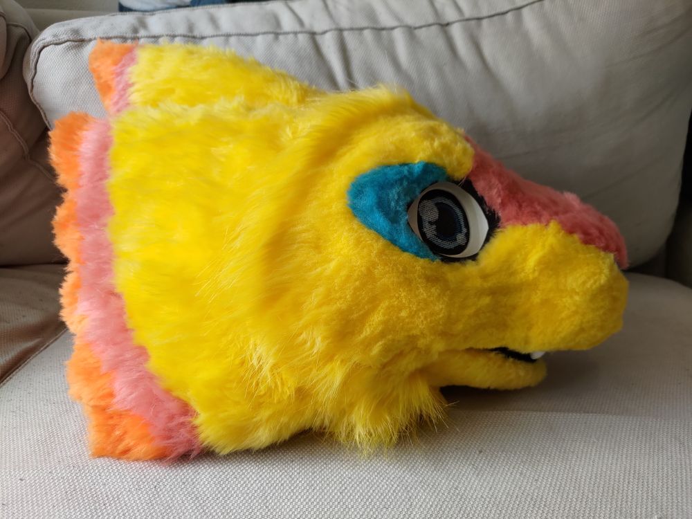 a photo of a mostly yellow fursuit head in profile view.