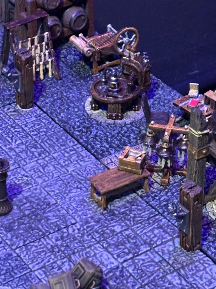 Zoomed in look at the candle making terrain.  Candles hang to dry.  Machines for rolling candles.  Alchemist table where the evil magic happens.