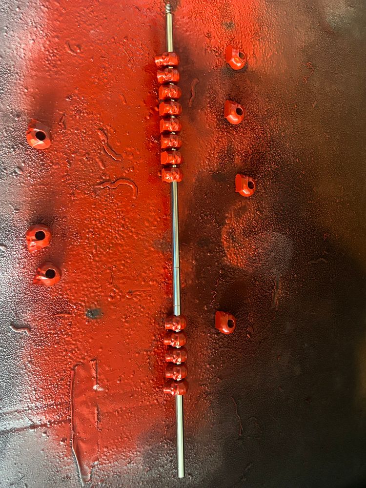 3D printed skulls painted red and slid on a metal rod.
