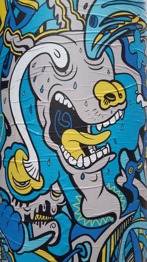 Buntes Plakat am Urban Loitz Platz in Wien. Einer schreienden Comicfigur springen die Augäpfel heraus.