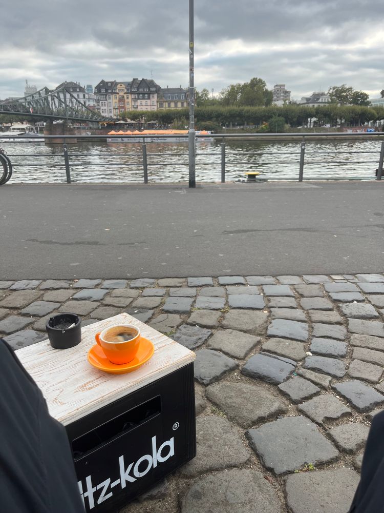 Sitze am Main vor mir eine Tasse Kaffee auf einem kleinen Tisch aus einem Kasten Fritz kola 