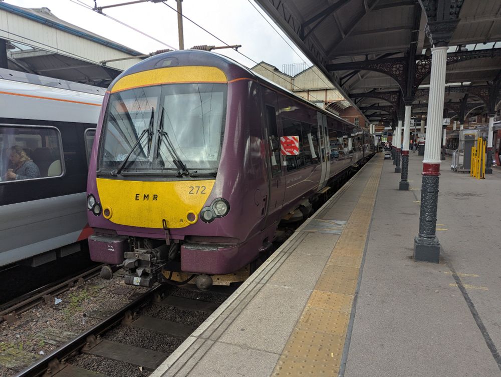 Purple class 170 272 at Norwich station. To the right is the platform and station canopy 