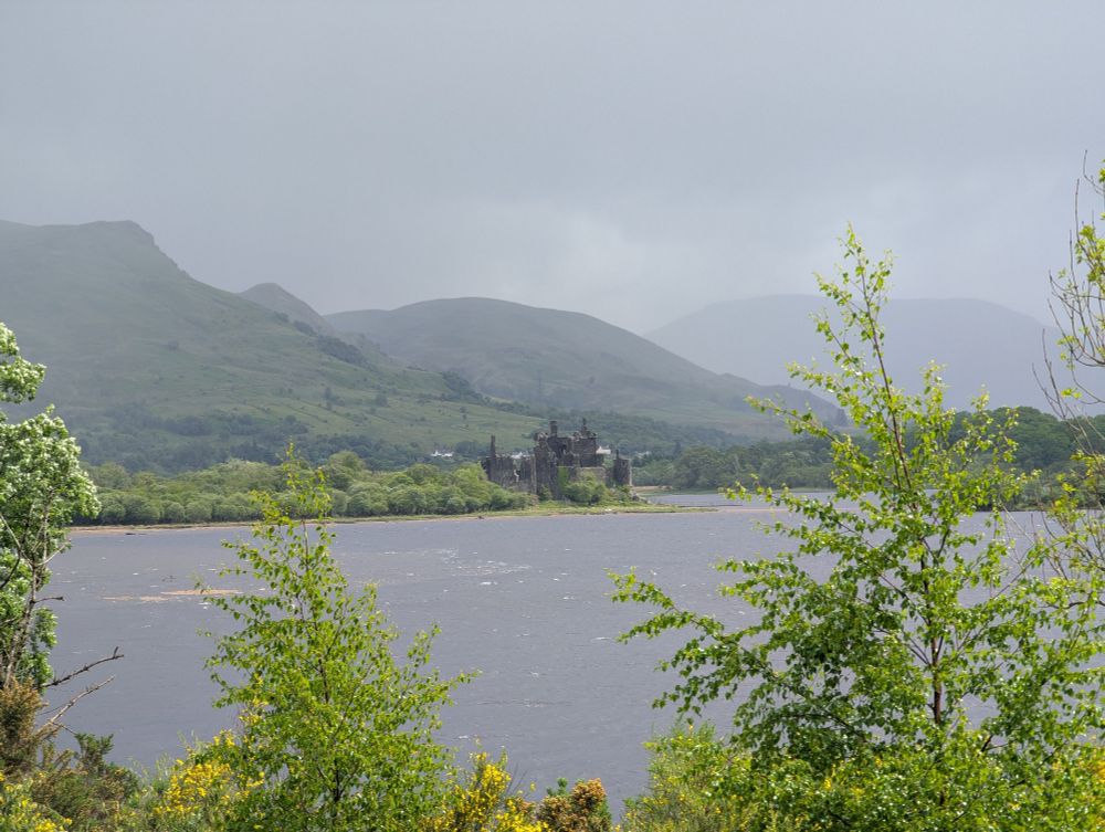 Kilchurn castle in the distance across the loch. Mountains in the background 