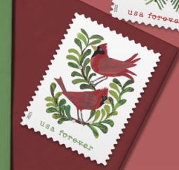 a usa forever forever stamp on a red envelope featuring two all-red cartoon cardinals on green leafy branches