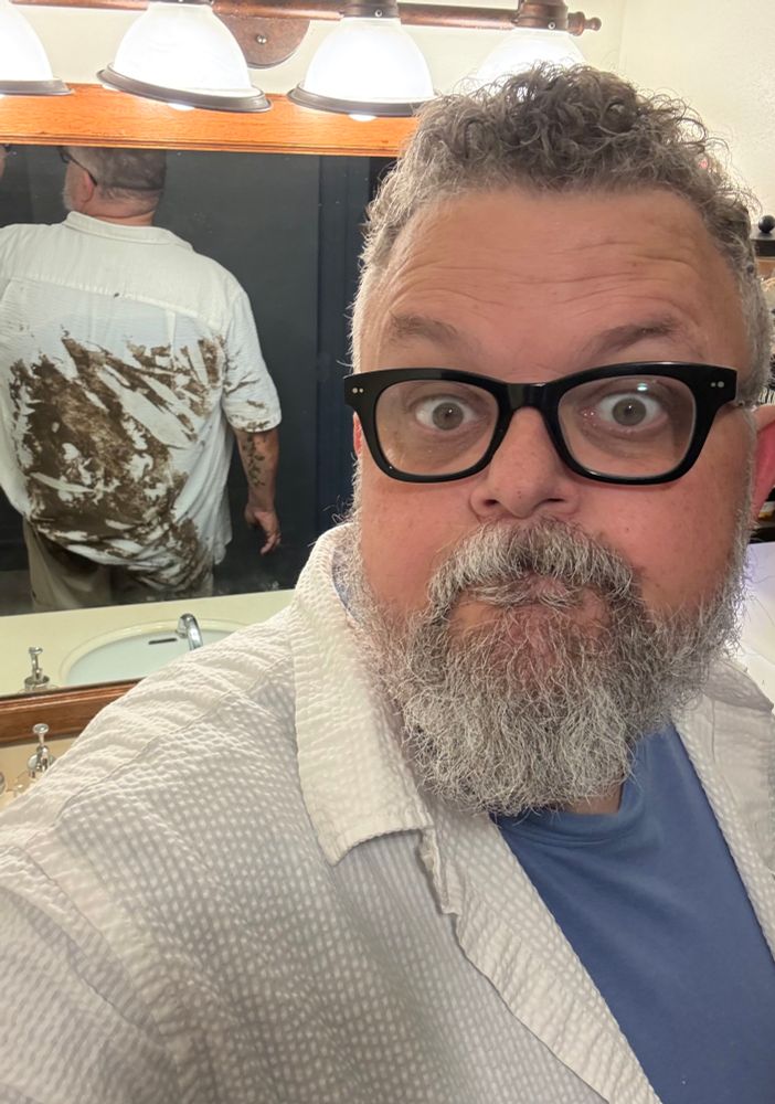 A bathroom selfie where are the mirror reflection shows my entire back full of mud