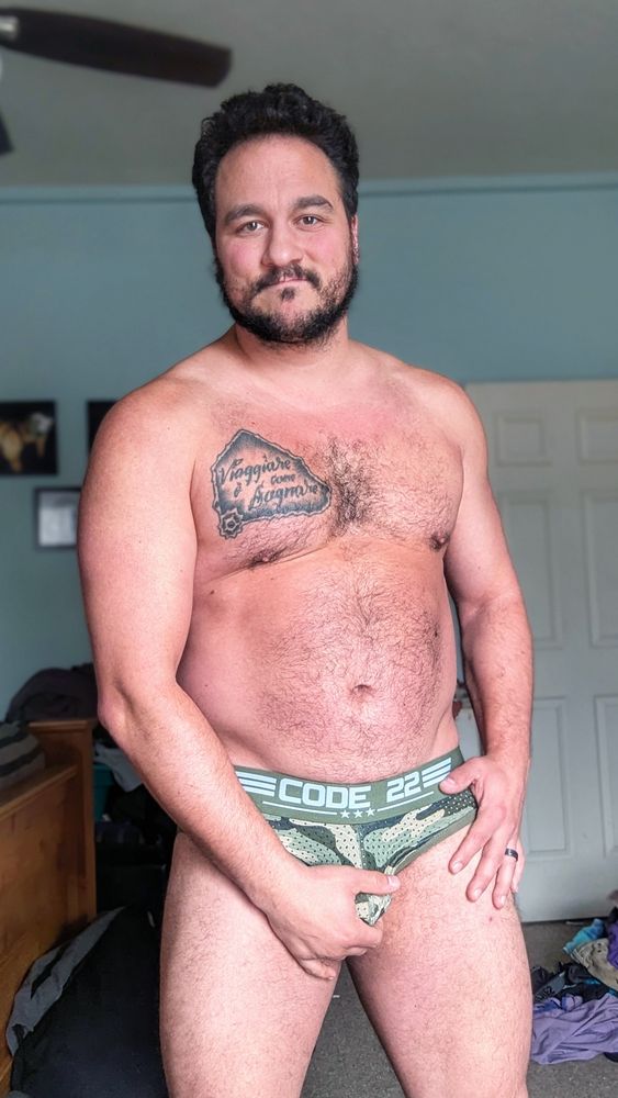 Rocky wearing camo colored briefs and holding his package