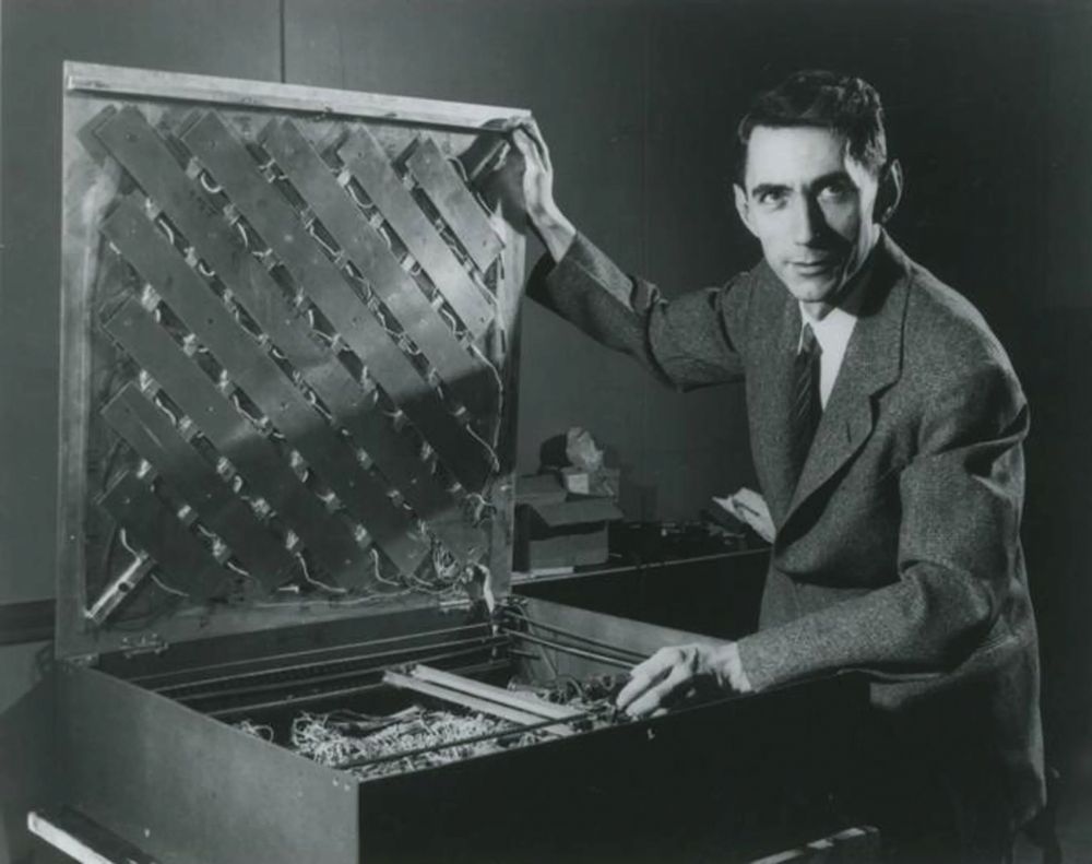 Claude Shannon with his electro-mechanical relay computer for solving mazes with a mouse, Theseus.