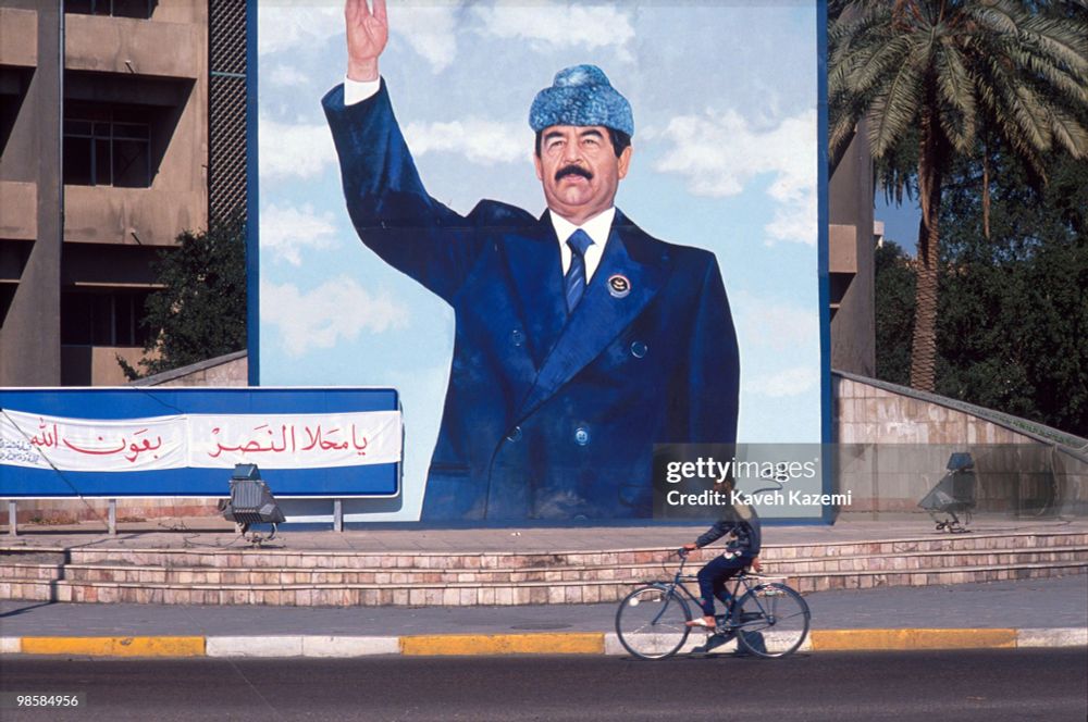 Portrait à la gloire de Saddam Hussein, ancien dictateur d'Irak dans une rue en février 1991.

En comparaison (du RT) du portrait de Donald Trump avec le slogan "American's workers first" s'affichant en grand sur la façade d'un immeuble américain