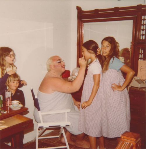 John Waters film goddess DIVINE applies lipstick to a young girl while other children watch