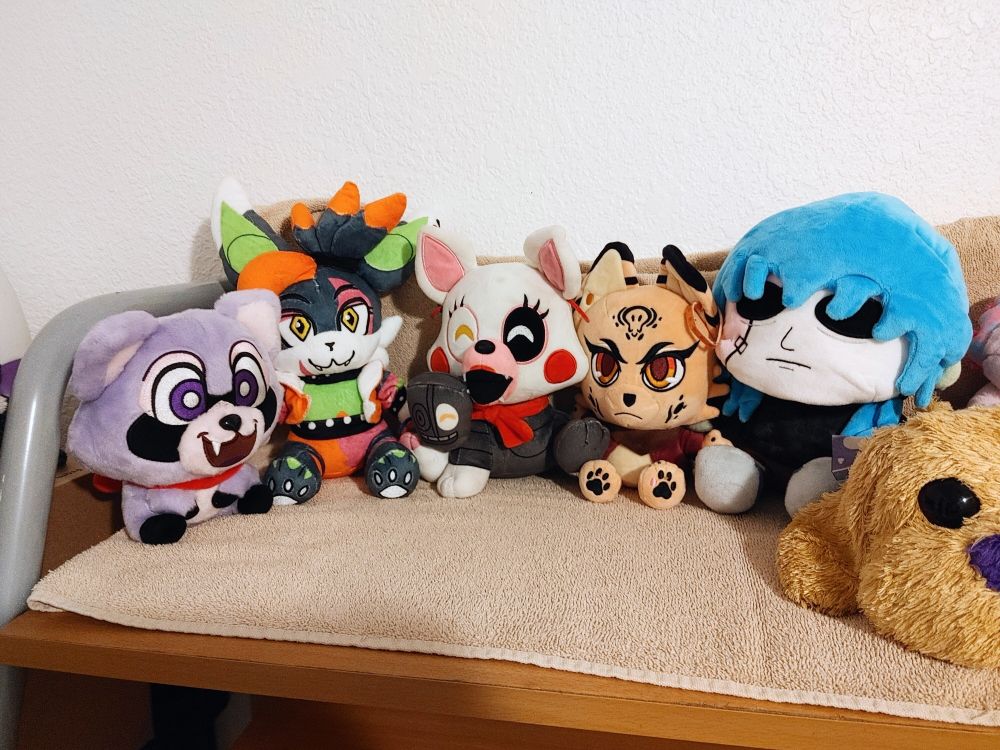 Zoomed out photo showing more plushies on the shelf. Rambley, Dusky, Mangle, Elaine from Billie Bustup, and Sal from Sally Face. Other non fandom plushies can also partially be seen.