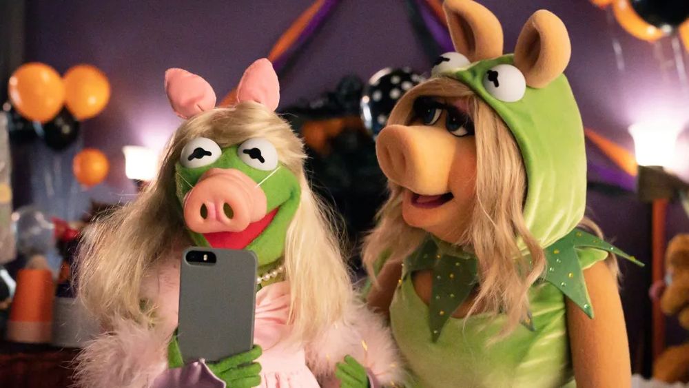 kermit wearing a piggy costume and piggy wearing a kermit costume
