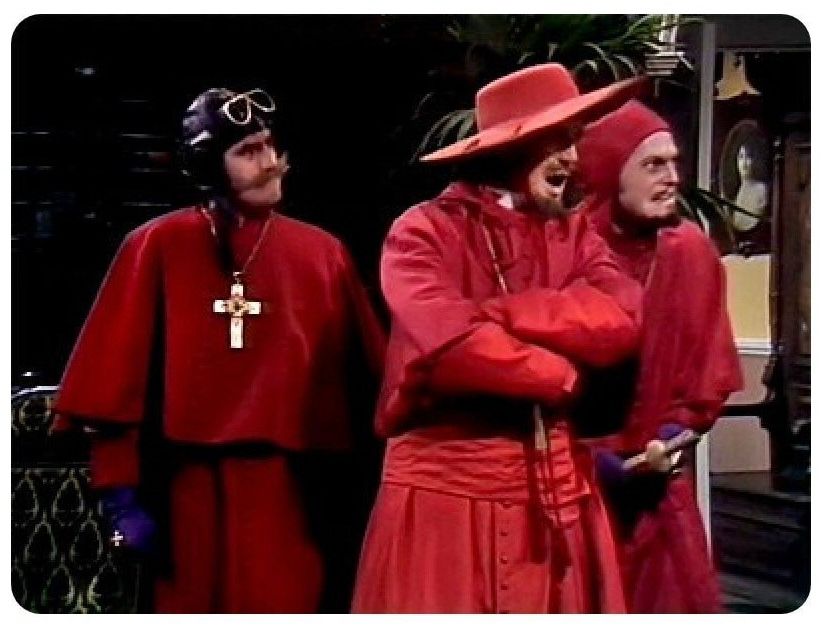 Three men dressed as Spanish inquisitors from Monty Python comedy sketch.