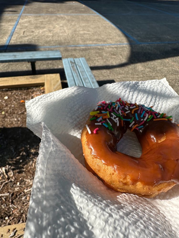 A close up of a home made chocolate iced donut.