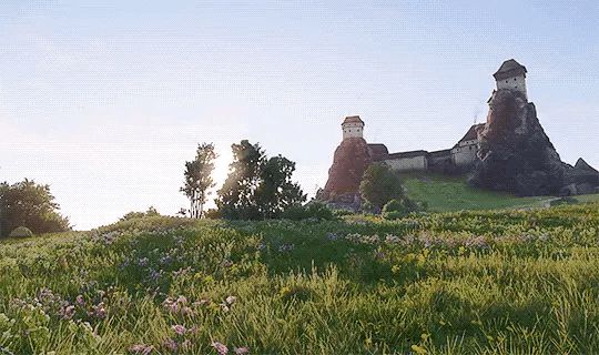 A landscape from KCD2 with a small castle in the background. 