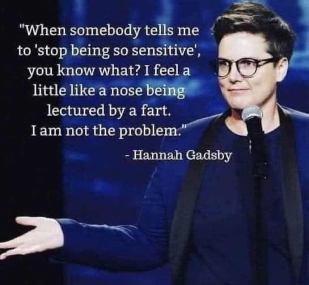 A photograph of the Australian comedian Hannah Gadsby with a text of her quote over the top. The image is of her standing in front of a microphone with her hand out and palms up with blue tones throughout. The white text over the top of the image says: “When somebody tells me to ‘stop being so sensitive’, you know what? I feel a little like a nose being lectured by a fart. I am not the problem. “ - Hannah Gadsby 