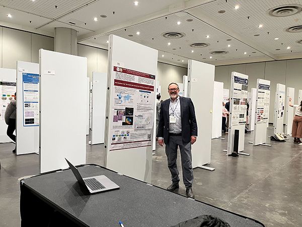 Alejandro Bugacov next to FaceBase's poster and table where he and Rob Schuler provided live demos