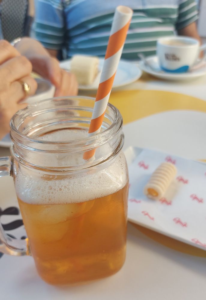 Jarra de té rooibos y maracuyá con hielo junto a un plato con un huesito de santo.