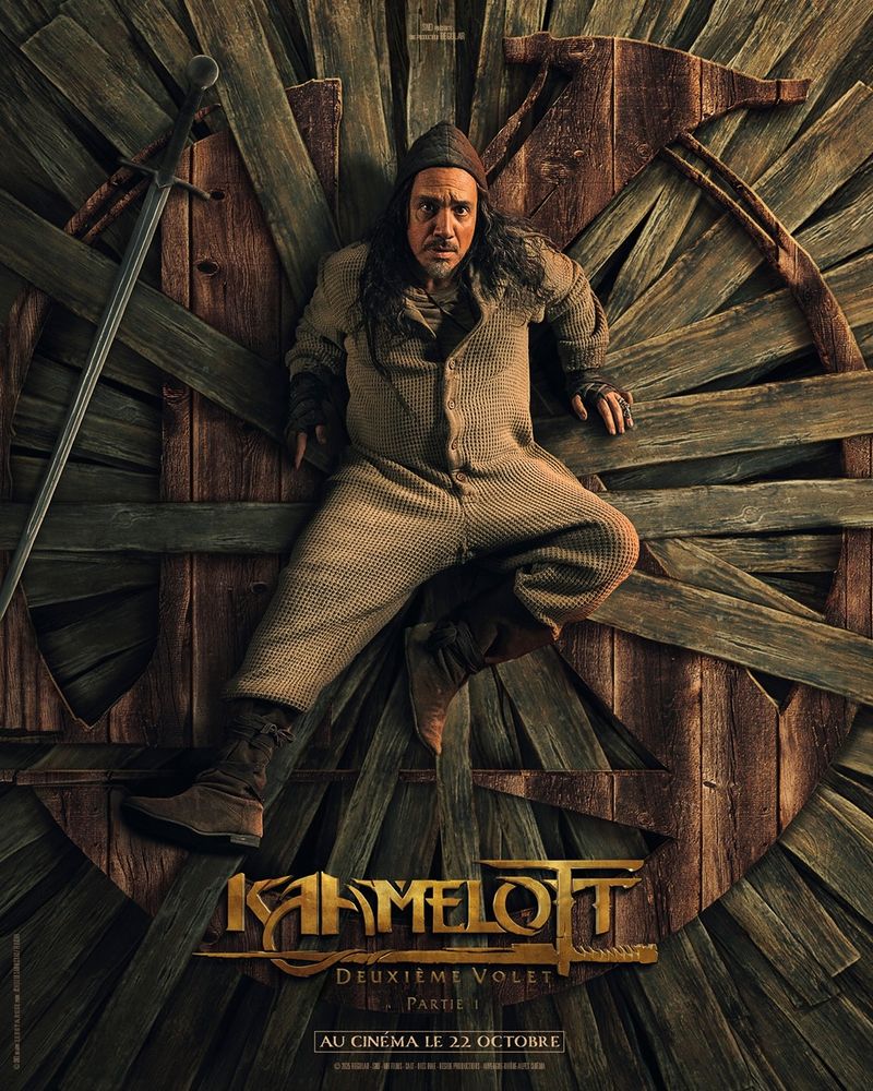 Un type allongé sur un logo géant fait de planches de bois.
Avec le titre Kaamelott dessous.