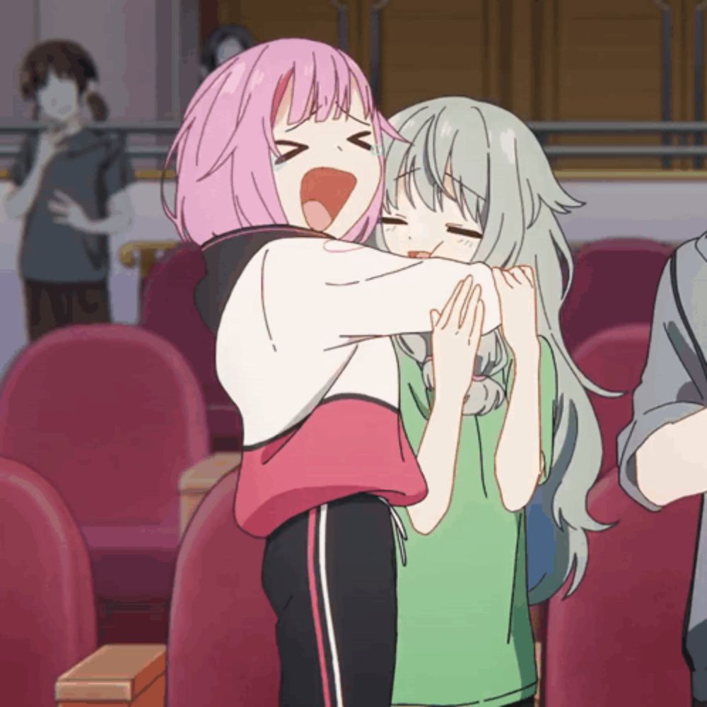 a girl with pink hair is hugging another girl