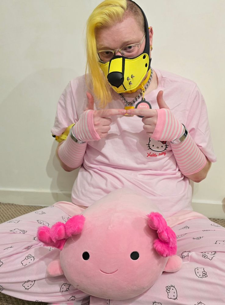 Me dressed in Hello Kitty PJs, with a Axolotl in my lap while I press my fingers together. 