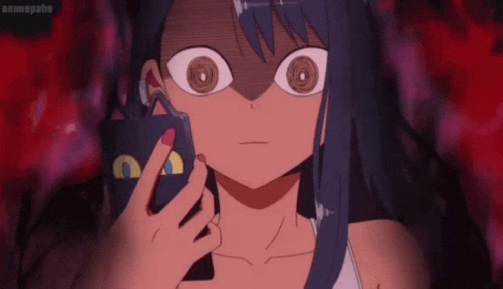 a girl is holding a cat shaped object in her hand and looking at it with big eyes