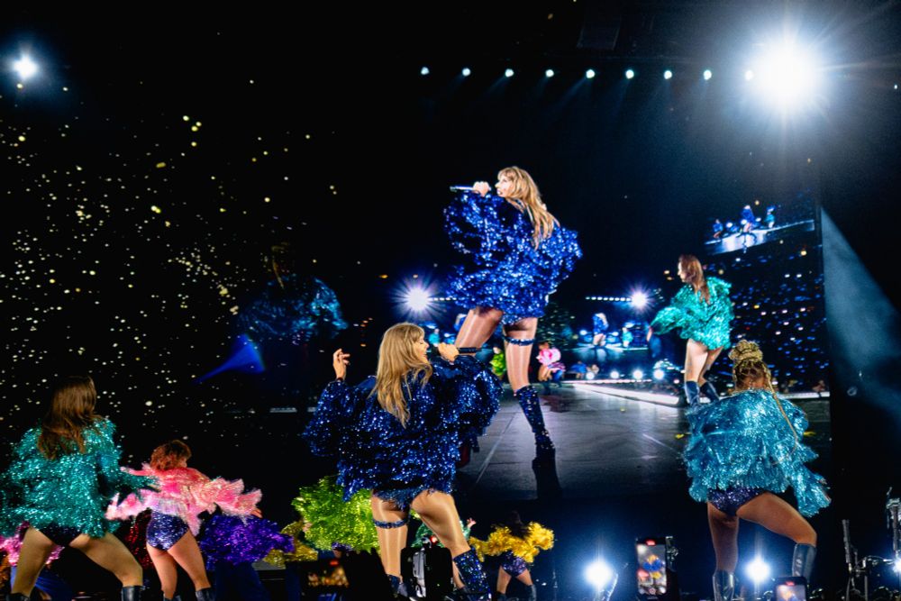 Taylor facing away from the camera, mid-hip shake during Karma, the hassles of her jacket moving and sparkling. 