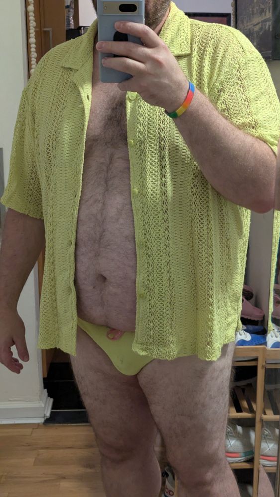 Same outfit without the shorts, showing the bright yellow speedo underneath, and now with the knit shirt buttons open exposing a fat, hairy belly