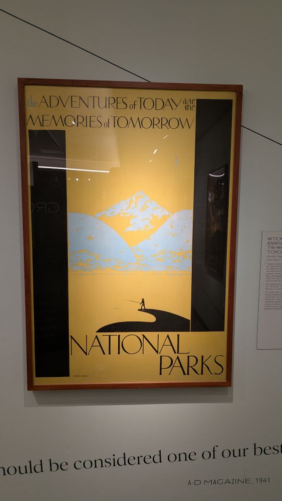 An advertisement poster for the National Parks designed by Dorothy Waugh that is striking in its abstract and minimal nature.  There's clearly a mountain range in the background in white, and in the foreground is an image of someone fishing in a lake, all in black.  The sky and lake are all yellow.  At the top it says "the Adventures of Today are the Memories of Tomorrow" and on the bottom it just says "NATIONAL PARKS"