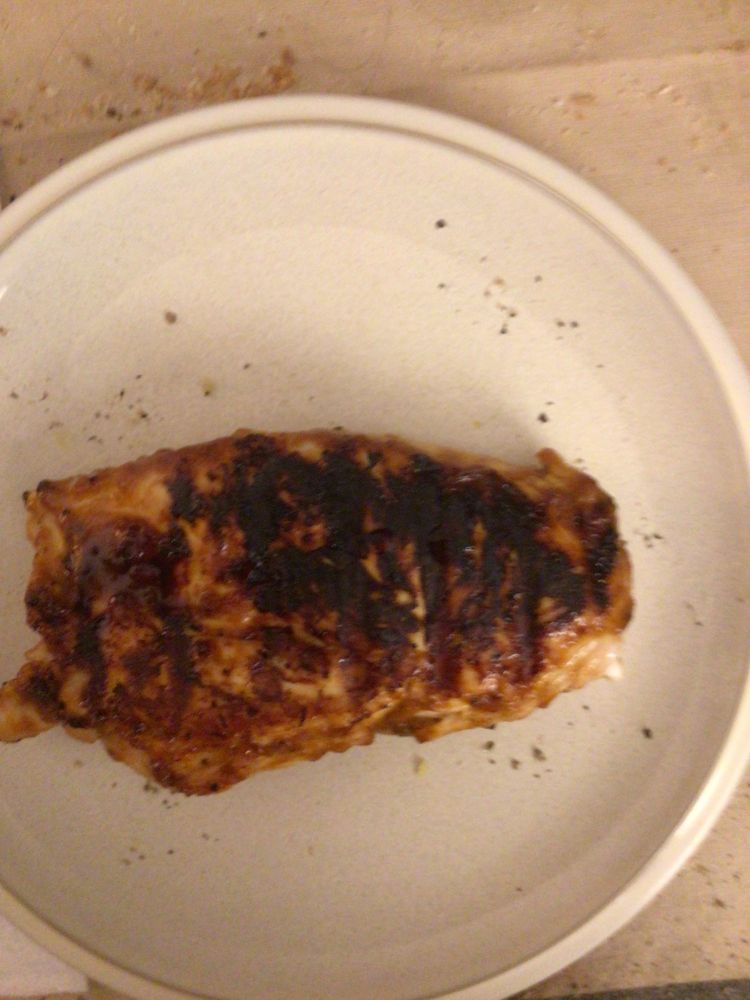 A nice portion of bourbon barbecue chicken on a beige dinner plate