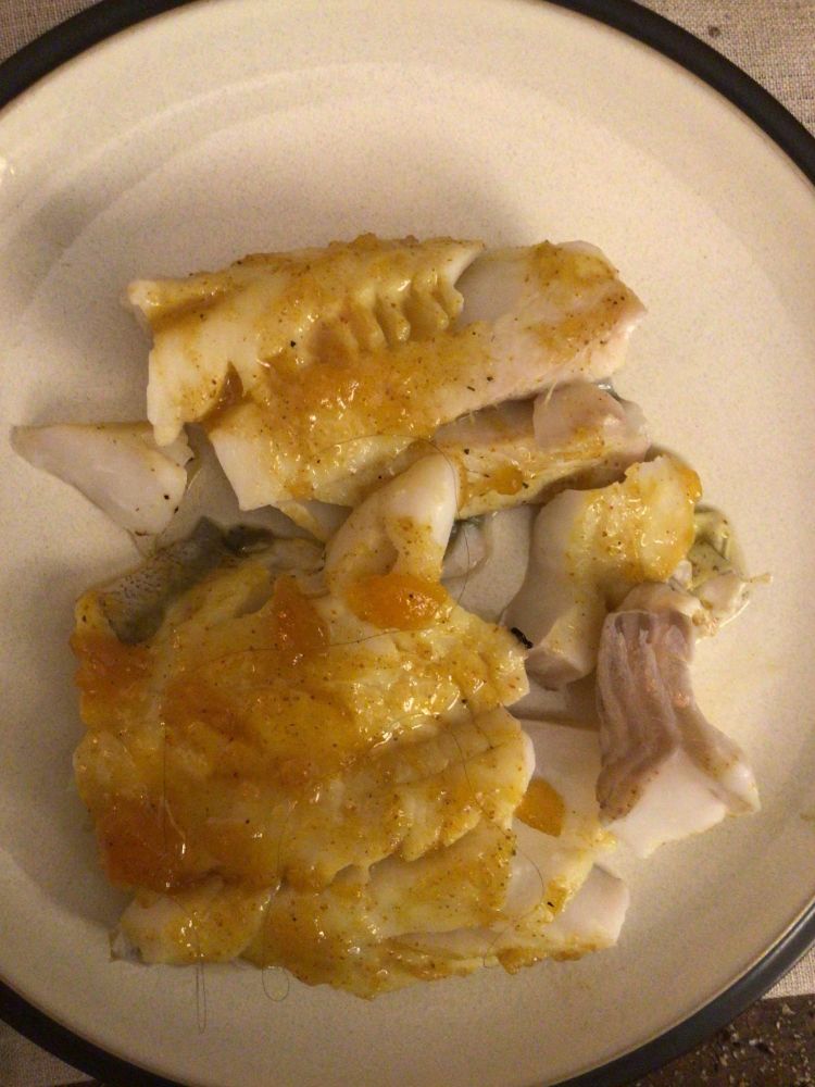 A generous portion of curried mango haddock on a dinner plate