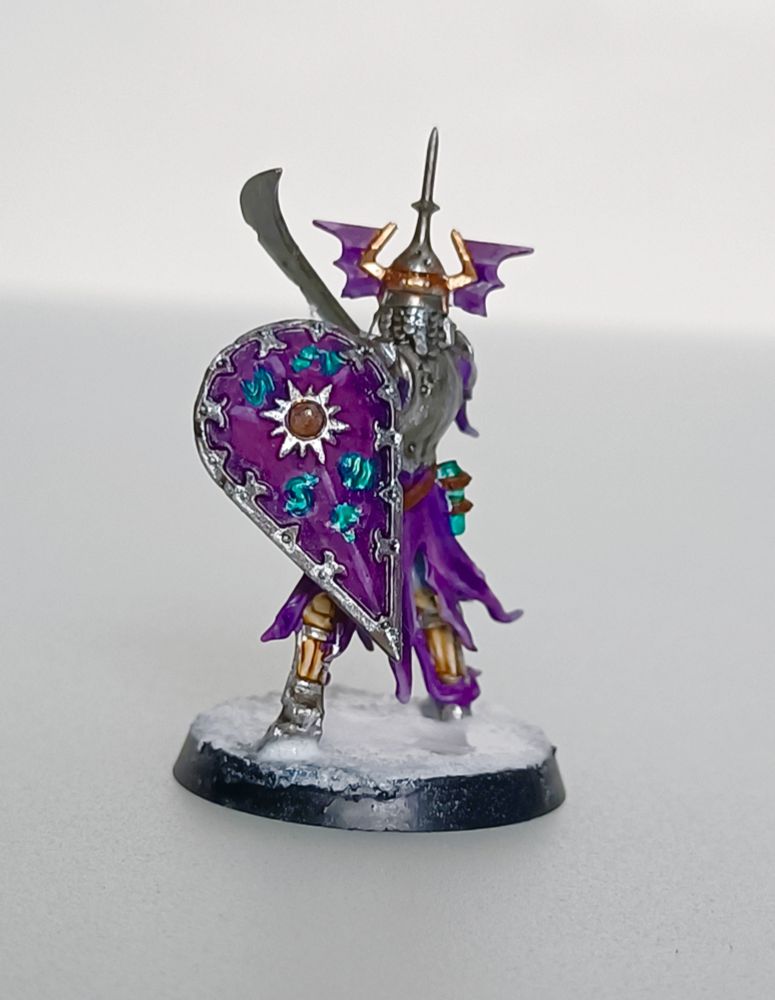 Pic of an undead warrior that wears Violet clothes and armor. He has a swords and a Violet and bronze shield 