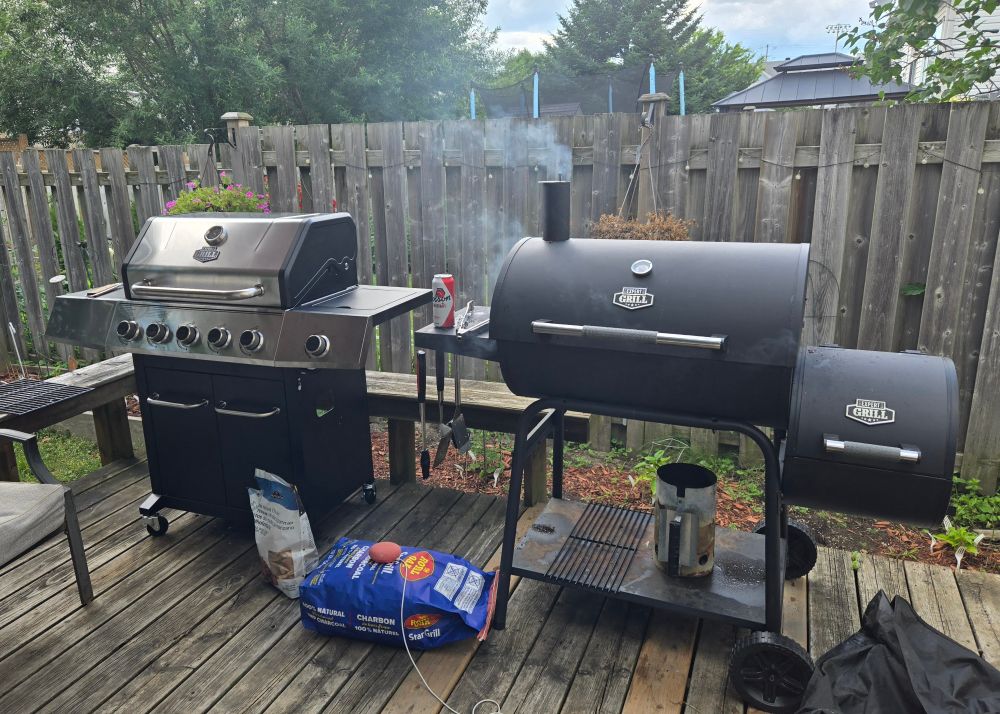 Propane barbecue next to a barrel barbecue with offset smoker.