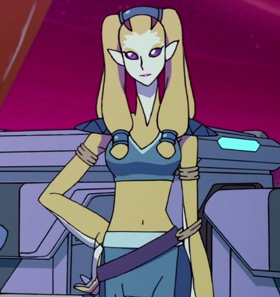 Nyma from VLD. She has yellow skin, pointy ears, and purple cat-like eyes. She is overall slim and is wearing a blue brassiere-like garment with shoulder pads and blue pants. She is posing with a hand on her hip.