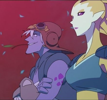 To the left Rolo, a purple alien with white hair. He's holding a little blade of grass between his teeth. To the right Nyma.