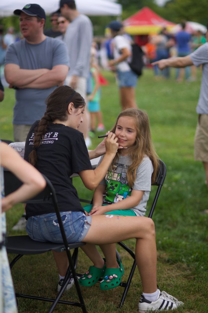 A girl gets her face painted at the Summer Game Spectacular.