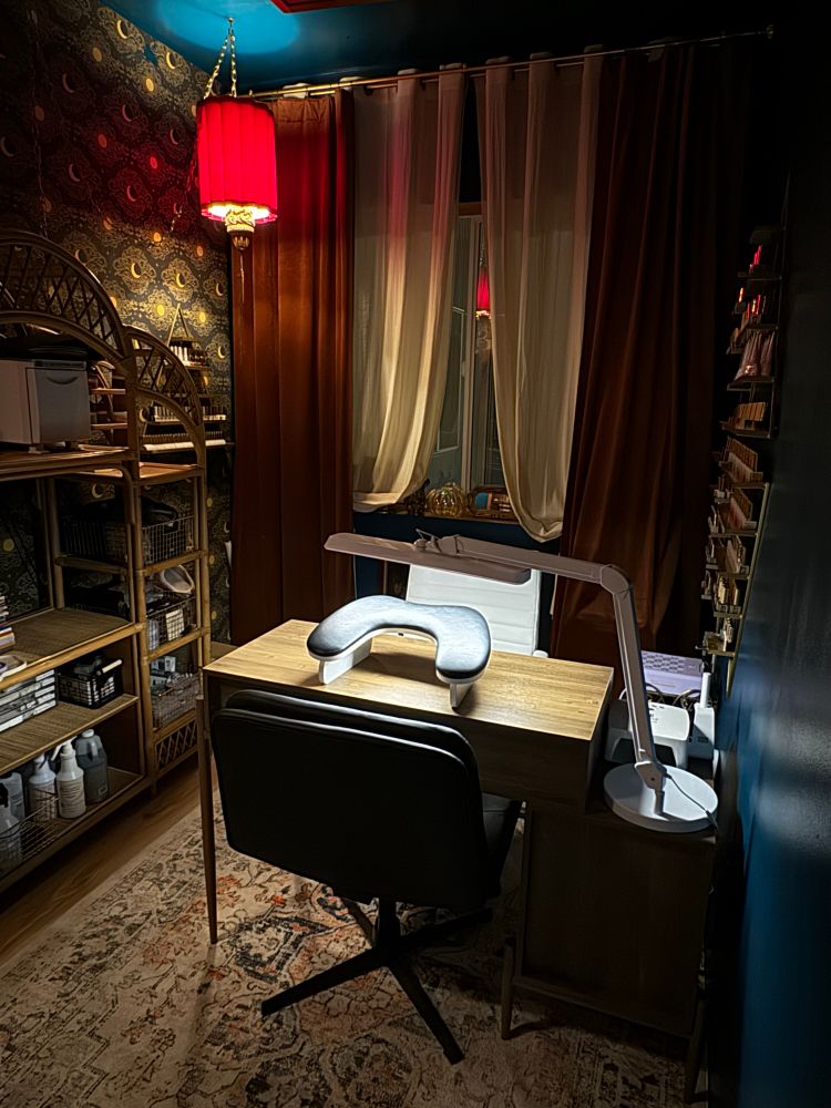 a small nail studio featuring low lighting, decorated with antique lamps and vintage charm. 
