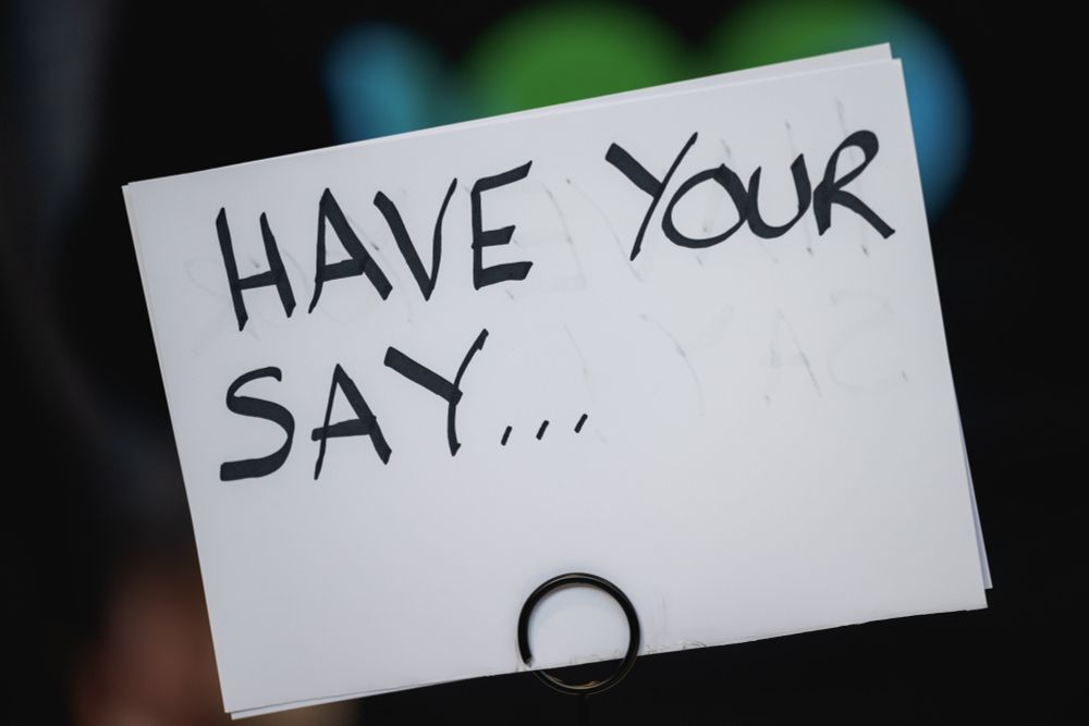 A notecard with the words 'HAVE YOUR SAY...'