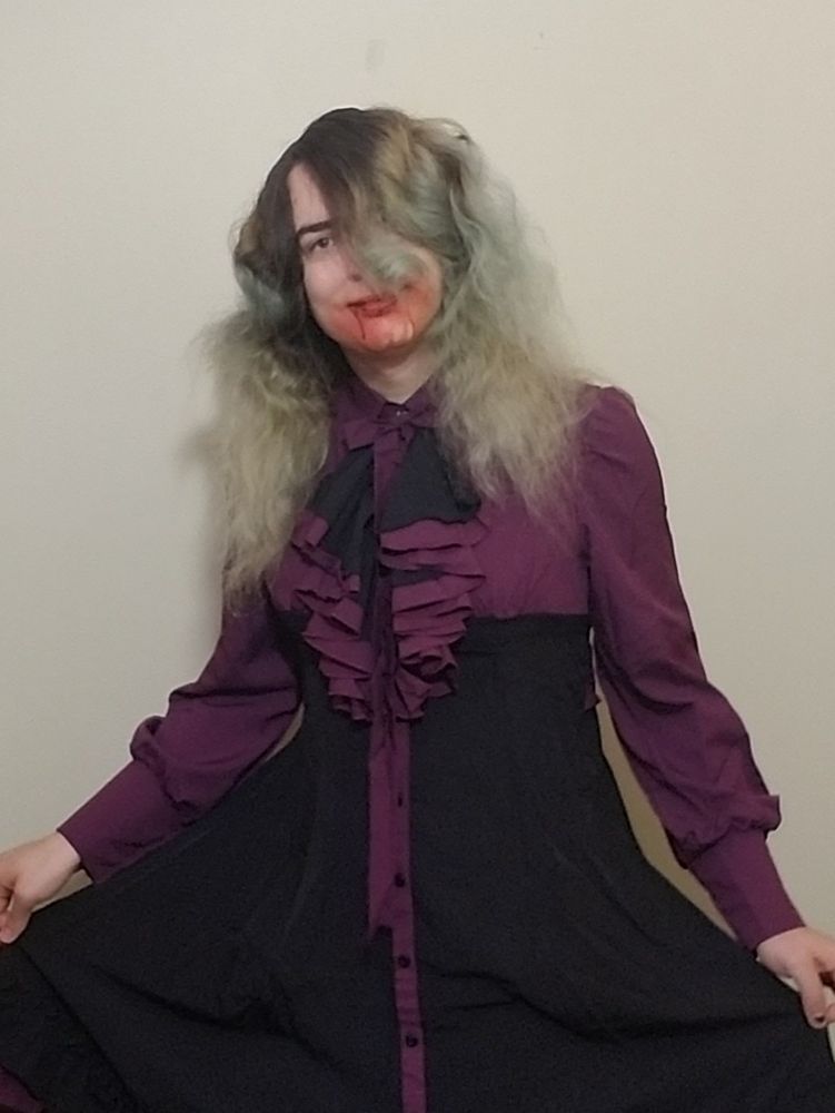 Me wearing a victorian vampire costume of a black/purple dress and fake blood around the mouth