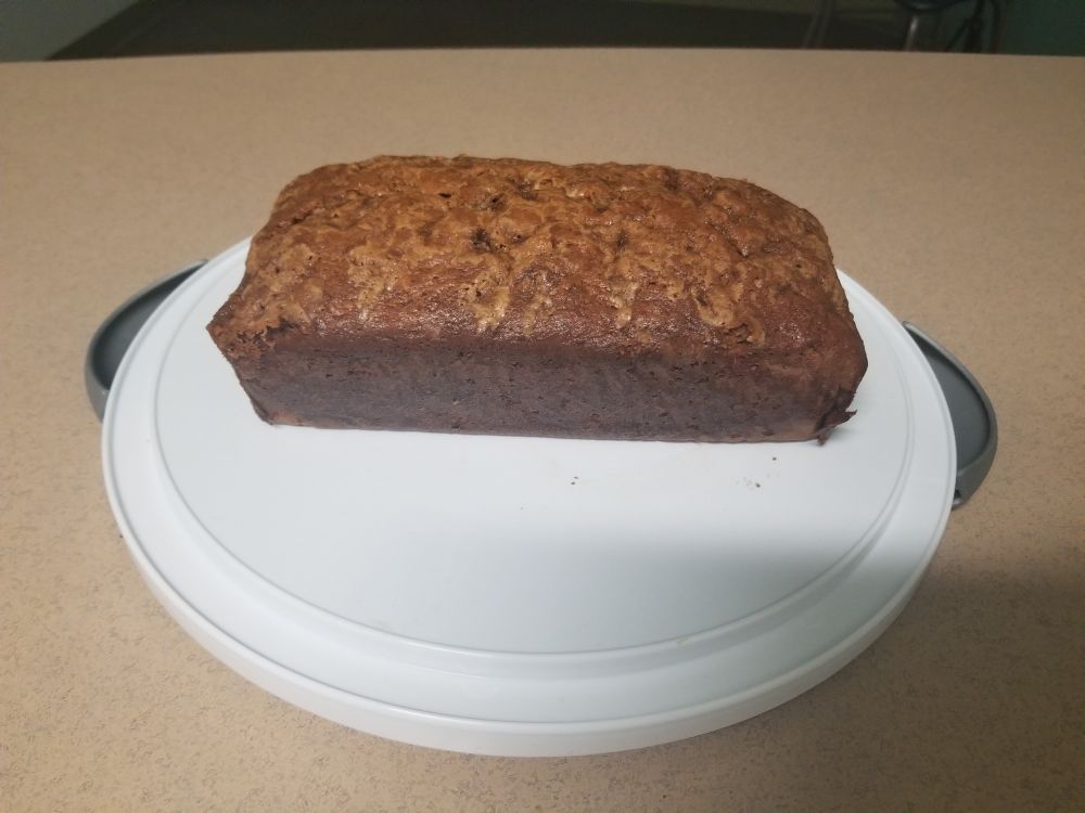 A loaf of banana bread sitting on a pastry platter