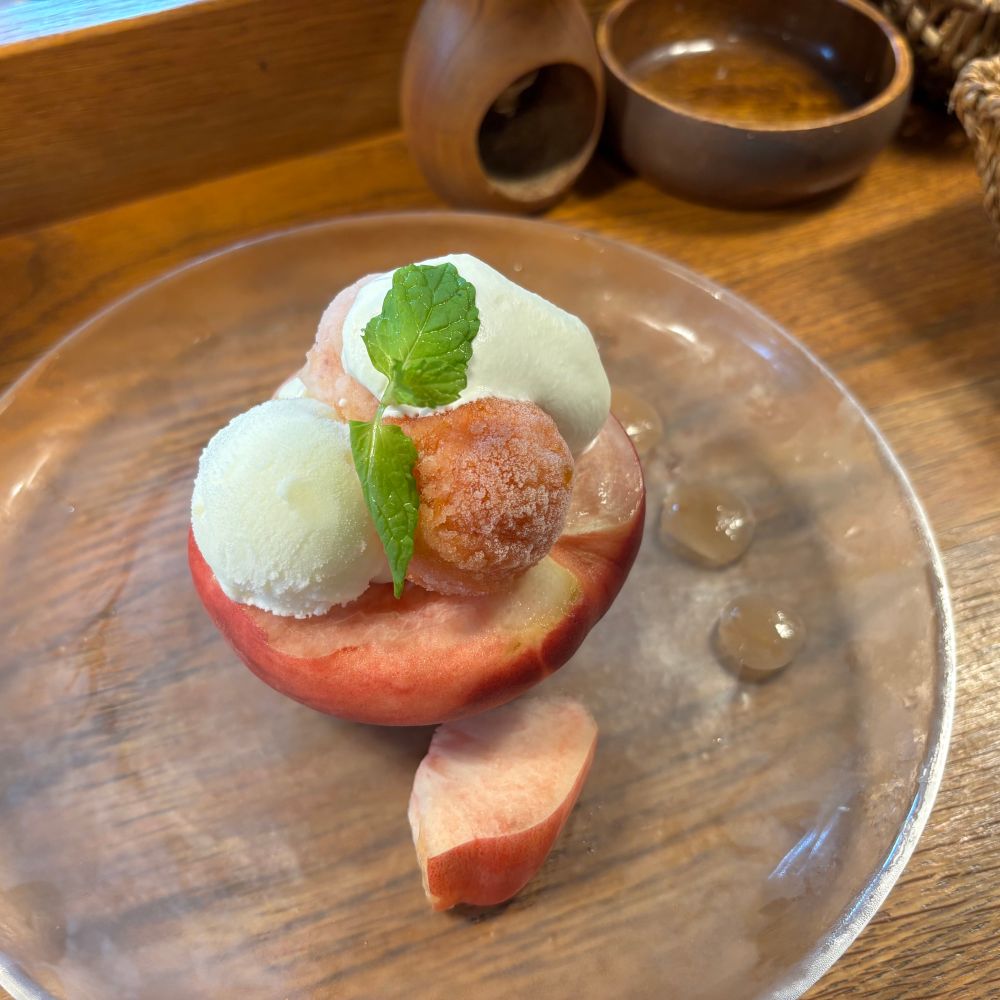 期間限定のももんにんII まるごと半分の桃の上にアイスが3種(もも・すもも・ヨーグルト)と杏仁豆腐がのっている