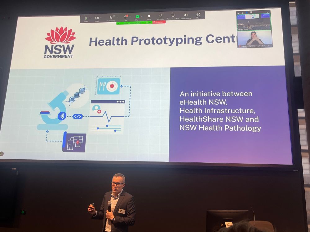 Image of Richard Talbot presenting his keynote at Digital Health Week. The slide on screen introduces the NSW Health Prototyping Centre