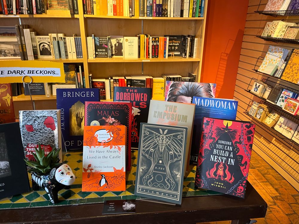A spooky-season book display, with John Wiswell’s SOMEONE YOU CAN BUILD A NEST IN prominently visible.