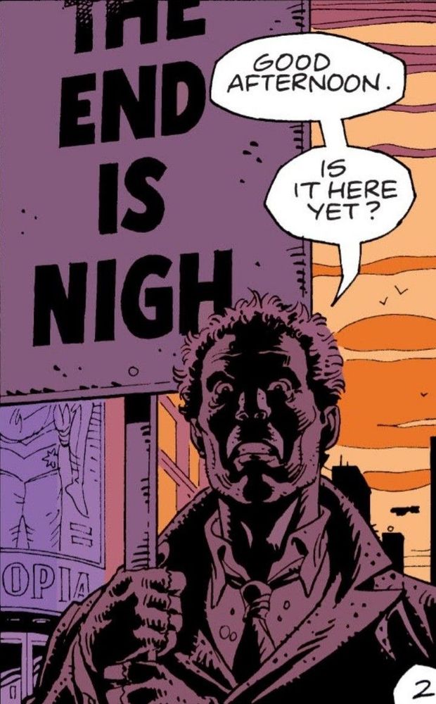 rorschach without his mask on. he holds a picket sign that says “the end is nigh”
