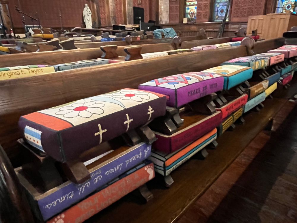 Hand-stitched kneelers are piled up in church pews