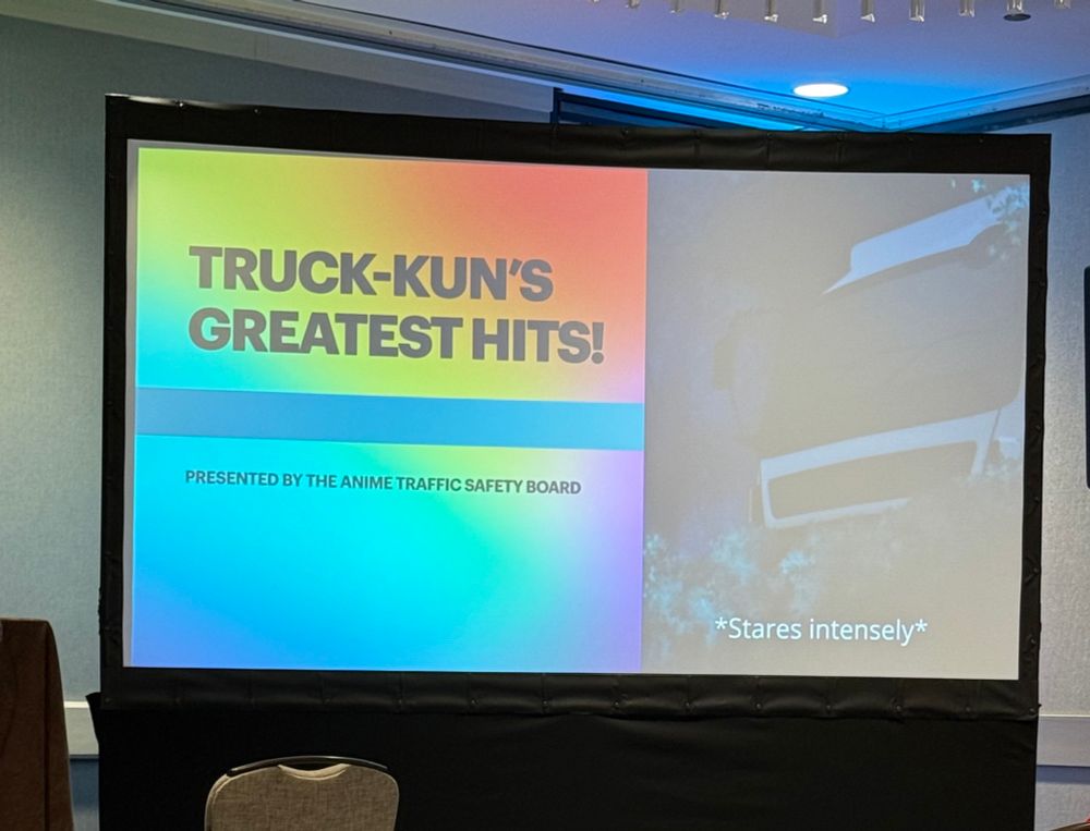 PowerPoint slide with the text “truck-kun’s greatest hits. Presented by the anime traffic safety board” with an image of an anime truck