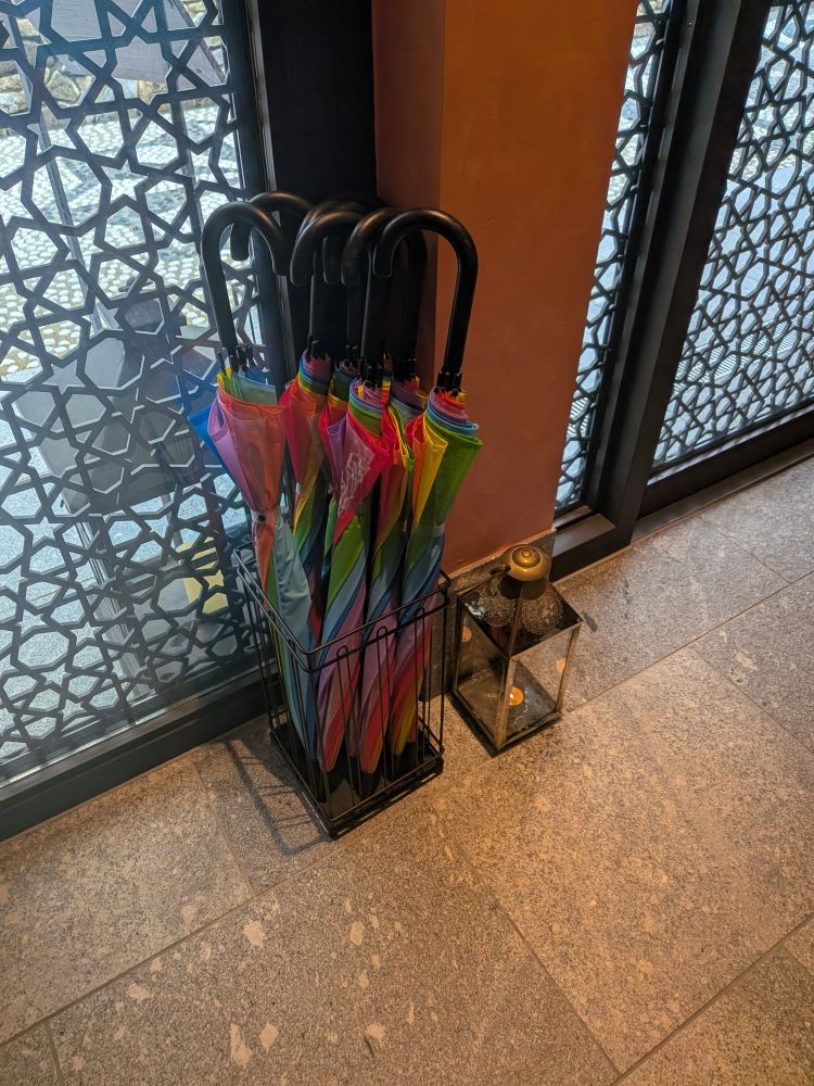 レインボーフラッグの色の傘が傘立てに何本も入っている