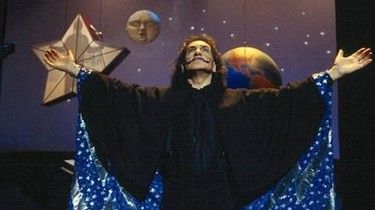 Ben Kingsley as The Great Zamboni in Spooky House (2002)

The Great Zamboni is in the middle of his magic act with his arms out stretched. Models of the Earth, Moon, and Star are suspended in the background. The star has the silhouette of a child inside as part of the magic act.