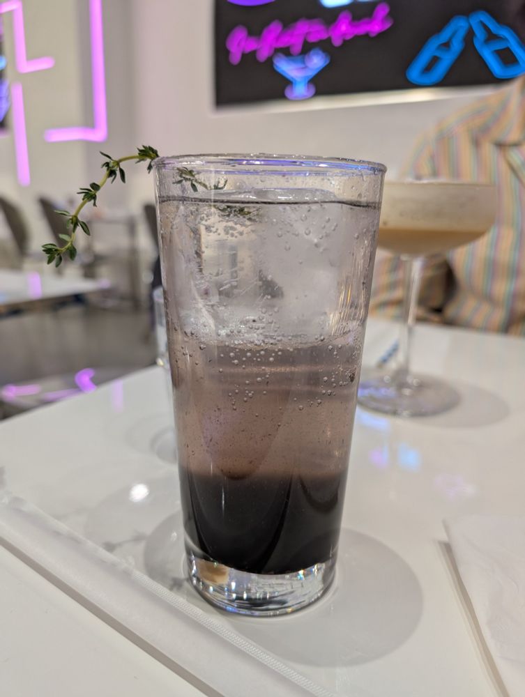 Unmixed blueberry drink with a sprig of thyme