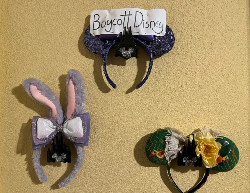 Various mouse ears on wall with Boycott Disney sign