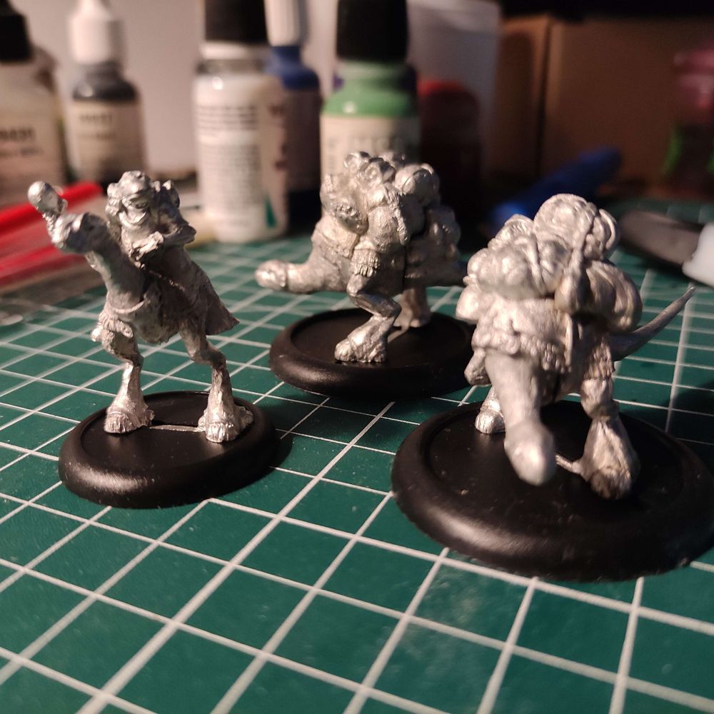 the metal miniature figurine reprensinting a fubarnii caravaneer and two laden Baruk from world of twilight: chronicles of Anyaral